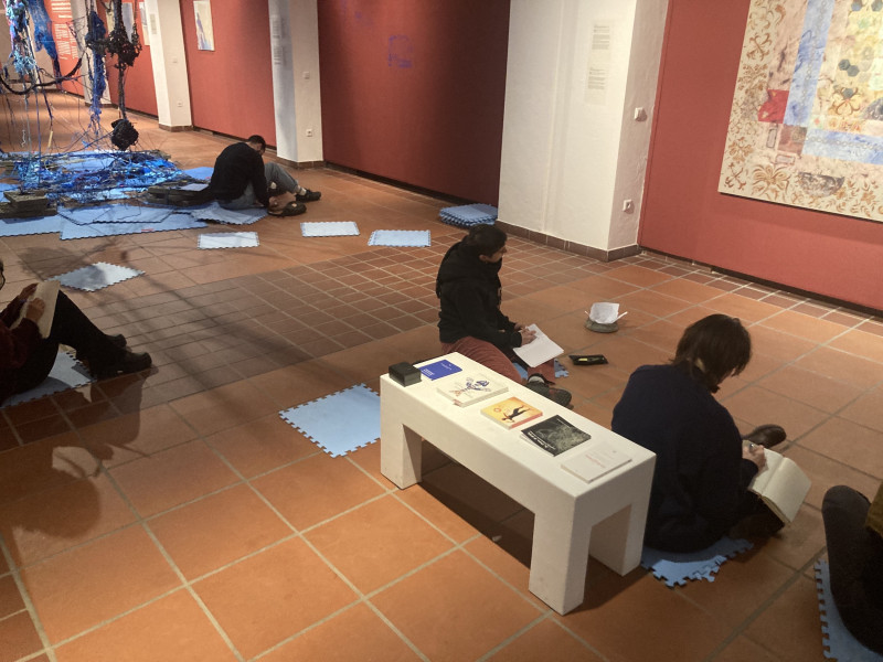 Leute sitzen am Boden der Galerie und schreiben