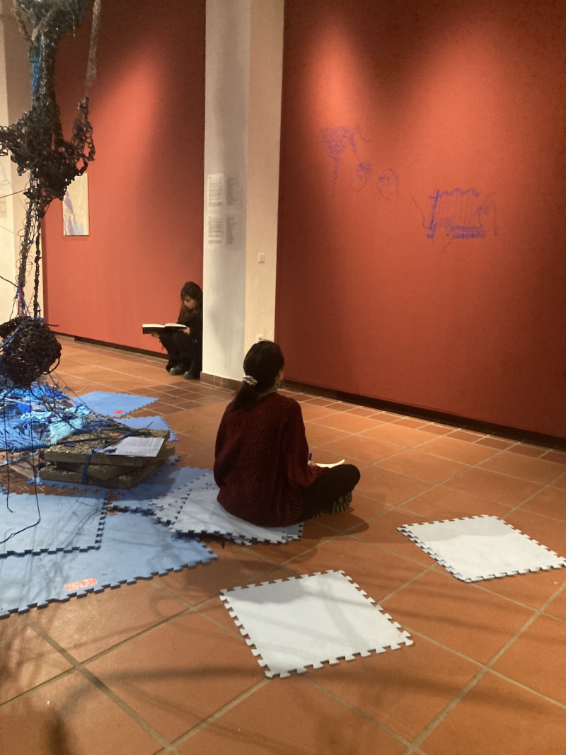 Leute sitzen am Boden der Galerie und schreiben