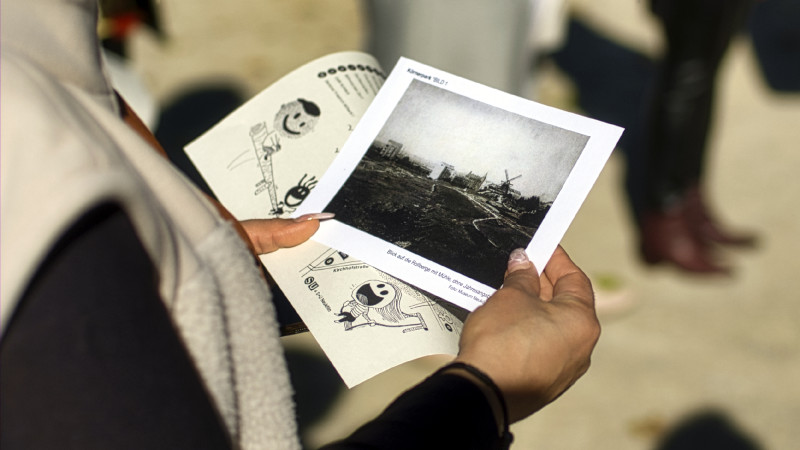 Hand hält ein schwarz weiß Foto einer Landschaft mit Windmühle