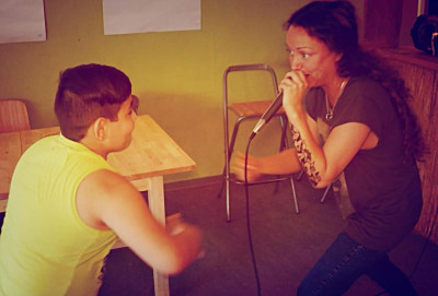 Eine junge Frau und ein Junge stehen sich gegenüber und Rappen