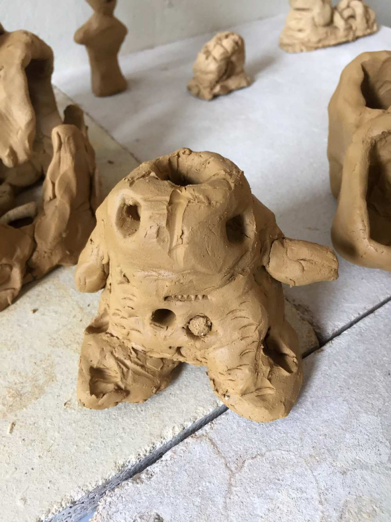 Monster aus Ton geformt, in der Mitte ist ein Loch im Kopf
